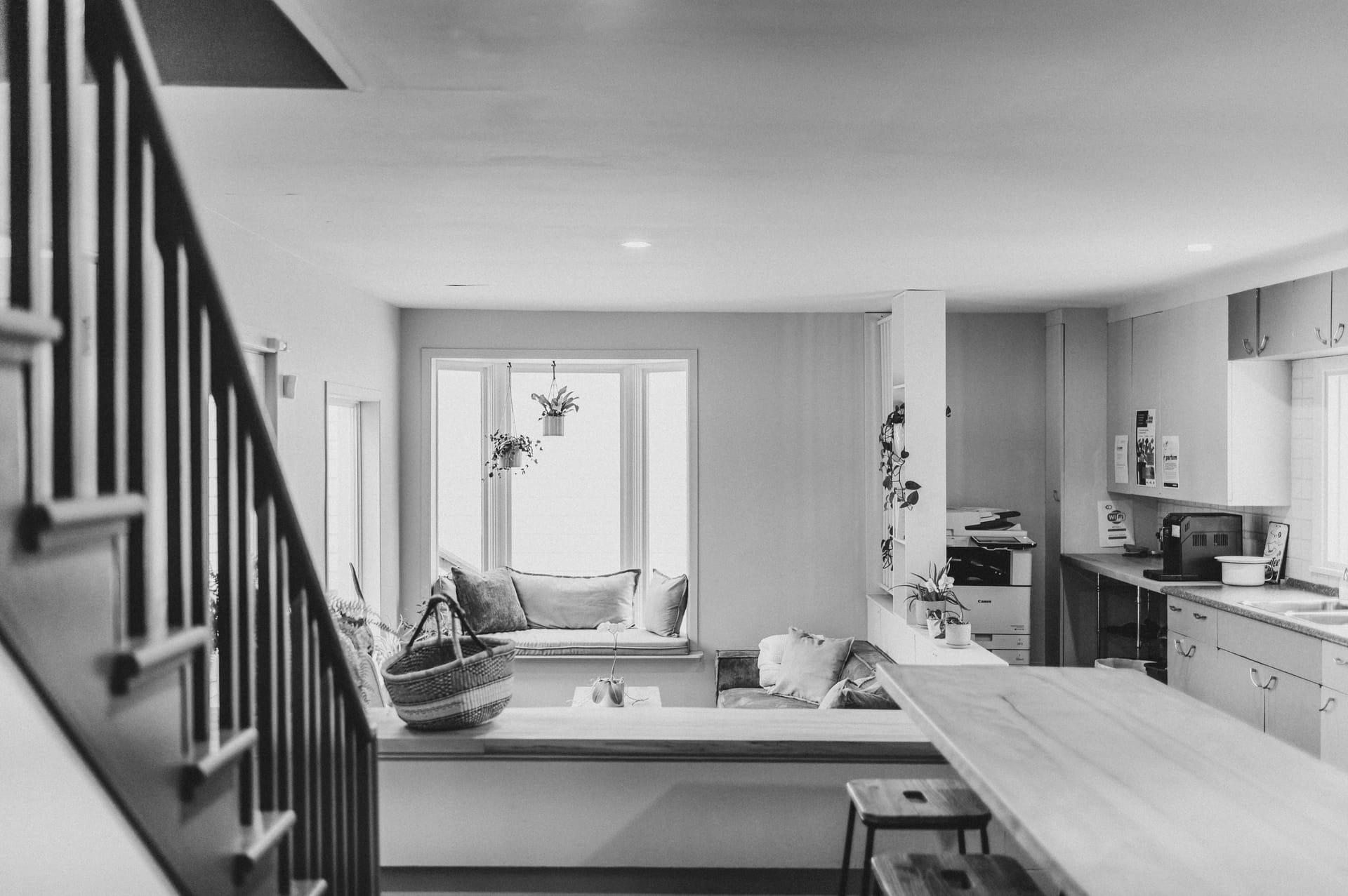 Espace Ko vu de l'intérieur — escalier vert, banquette baie vitrée, cuisine commune en arrière-plan